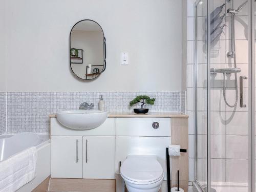 a bathroom with a sink and a toilet and a mirror at Contractor Stay Hatfield with Free Parking Sleeps 4 in Hatfield