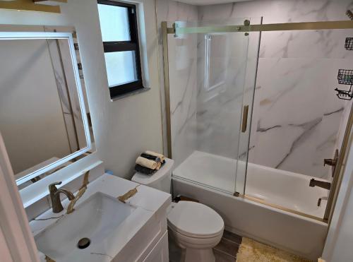 un bagno con lavandino, WC e doccia di Parkshore resort apartment a Naples