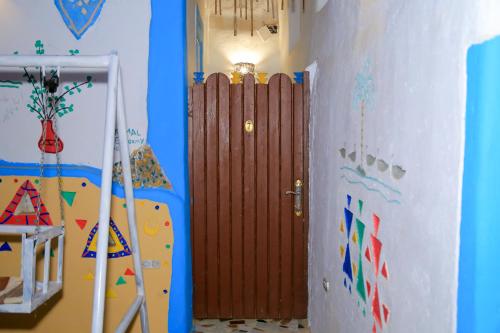 a room with a wooden door in a room at Nubian Palace Eco Lodge in Aswan