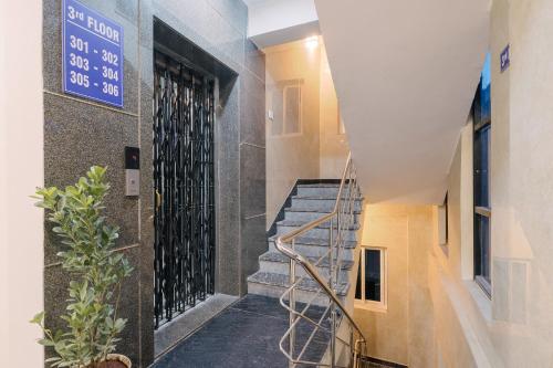 a staircase in a building with a blue sign on the wall at Hotel Saffron Groves in Hyderabad