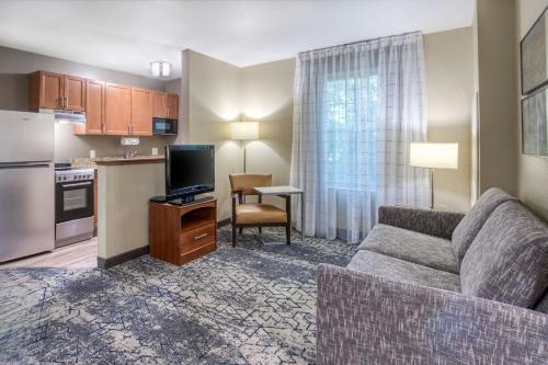 a living room with a couch and a kitchen at TownePlace Suites Raleigh Cary/Weston Parkway in Cary