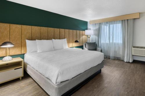 a hotel room with a large bed and a chair at Best Western Portland West Beaverton in Portland