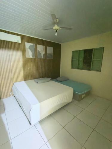 a bedroom with a white bed and a couch at Casa Lins para 15 pessoas in Lins