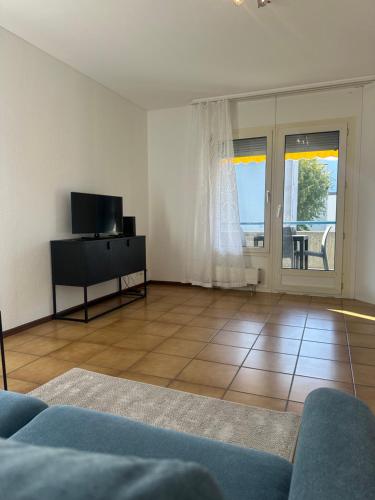 a living room with a blue couch and a television at BelliCastelApartment in Bellinzona