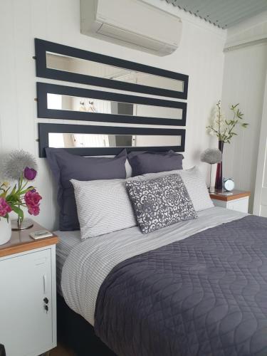 a bedroom with a bed with a black and white headboard at The Cube in Martinborough 