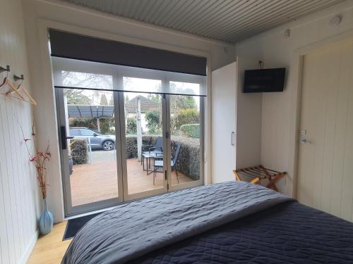 a bedroom with a bed and a sliding glass door at The Cube in Martinborough 