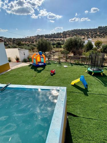a backyard with a swimming pool and a playground at Monte da Rochela in Vila Viçosa