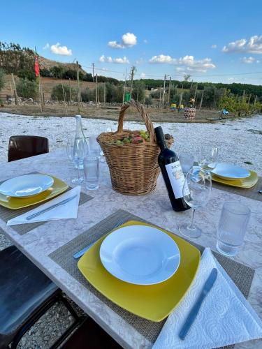 a table with yellow plates and a bottle of wine at Monte da Rochela in Vila Viçosa