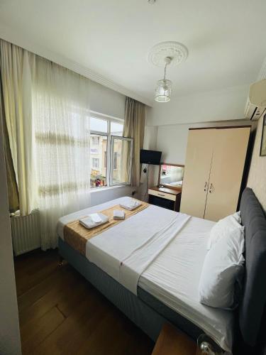 a bedroom with a large bed and a window at Kalamari pansiyon 2 in Adalar