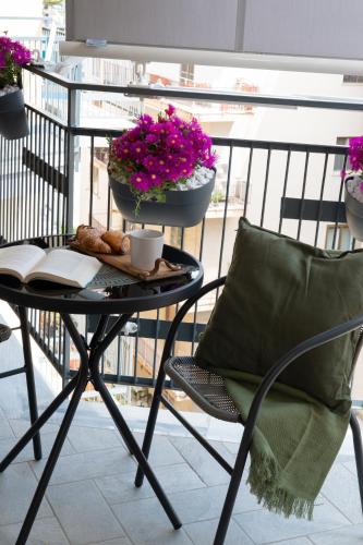 een tafel en een stoel op een balkon met bloemen bij Casa Teresinella Pompei in Pompei