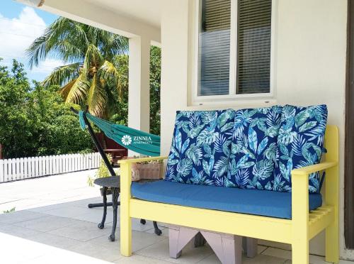 a porch with a yellow and blue bench and a hammock at Zinnia Apartments Antigua in Potters Village