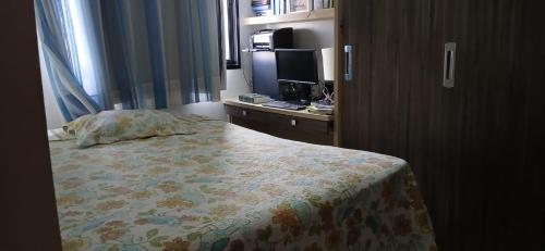 una camera con un letto e un comò con una televisione di Apartamento 2 quartos COP 30 a Belém