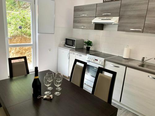 a kitchen with a table with wine glasses on it at Chata554 Domaša Valkov in Bžany