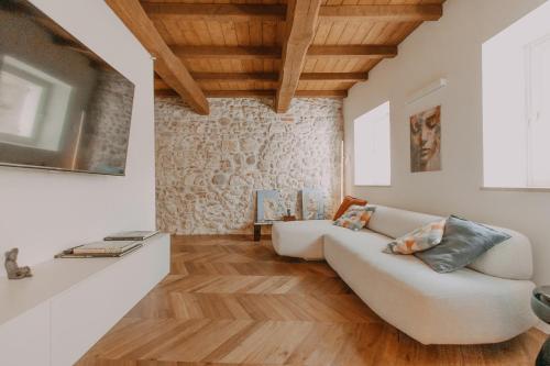 sala de estar con sofá blanco y suelo de madera en Fascino in Centro with private parking and two Rooms, en Ascoli Piceno