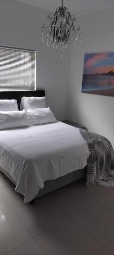 a bedroom with a large bed with a chandelier at Solomon's Nest in Glencairn