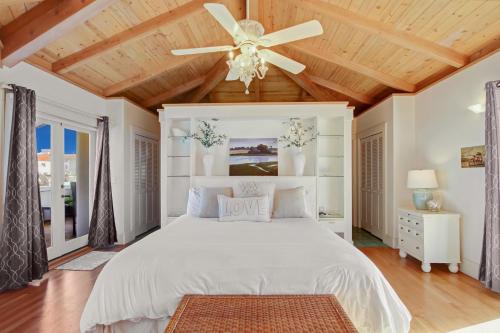 a bedroom with a white bed and a ceiling fan at Casa Azzurra in Santa Barbara