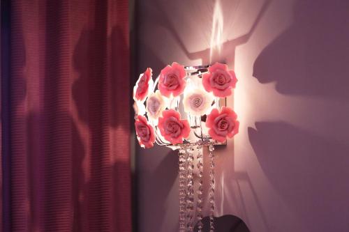 a light with pink roses on a wall at Buckingham Palace B&B in Beipu
