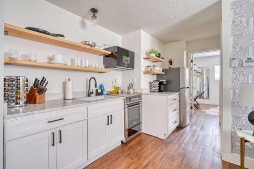 Una cocina con gabinetes blancos y electrodomésticos de acero inoxidable. en Stay Portland - Beautiful Brooklyn 1 Bed Apt, en Portland