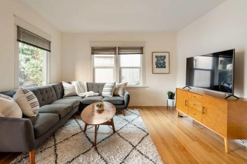 a living room with a couch and a tv at Stay Portland - HeartofBuckman MidCentury Dream 86 WalkScore 3BR in Portland