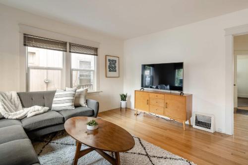a living room with a couch and a tv at Stay Portland - HeartofBuckman MidCentury Dream 86 WalkScore 3BR in Portland