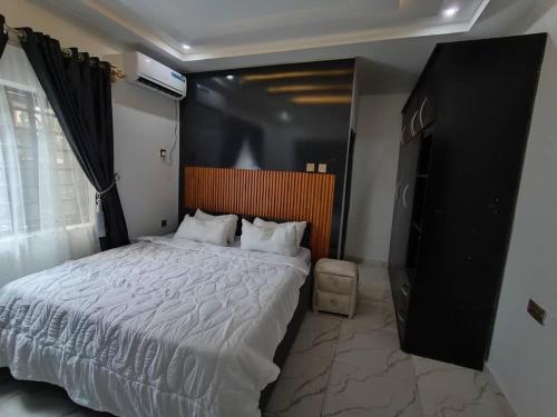 a bedroom with a large bed and a television at Ike Service Apartments in Owerri