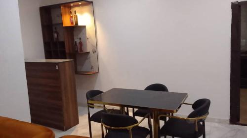 a table and chairs in a room with a refrigerator at Ike Service Apartments in Owerri