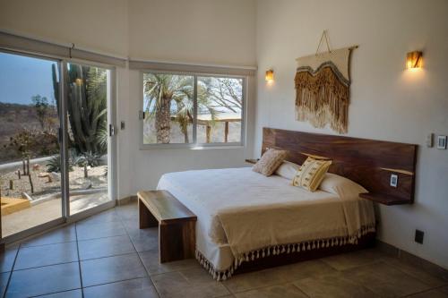 a bedroom with a large bed and a large window at Casa Cumbres - Ocean View in Puerto Escondido