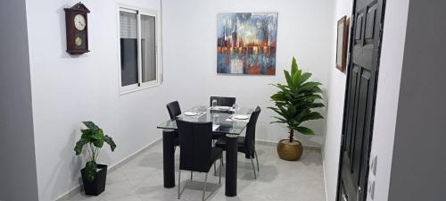 a dining room with a table and chairs and a clock at Maison de cèdre in Azrou