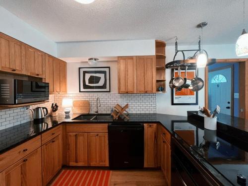 a kitchen with wooden cabinets and a black appliances at The Magic Teacup in Davis