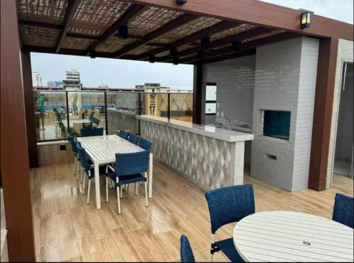 Un balcón con mesas y sillas en un edificio. en NOVO frente ao Mar - 750m da Orla e Pq dos Ventos - Oceanfront - 3 Guests, en Salvador