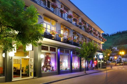 a building on the side of a street at night at The Originals City Hotel de l Ange Guebwiller in Guebwiller