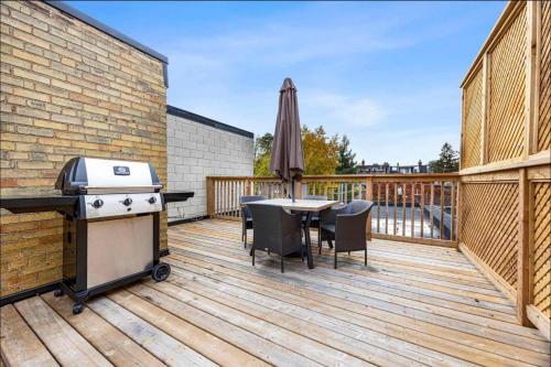 a patio with a grill and a table on a deck at Casa Hotel Stylish Modern Family Suite with Patio in Toronto