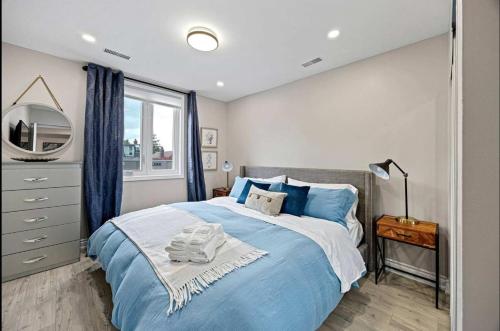 a bedroom with a blue bed and a mirror at Casa Hotel Stylish Modern Family Suite with Patio in Toronto