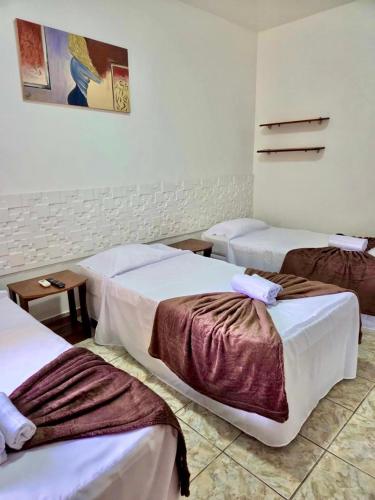 a hotel room with three beds in a room at Hotel Paraiso Belém in Belém