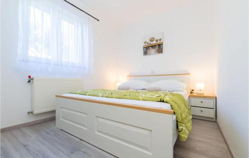 a white bedroom with a bed and a window at Gorgeous Apartment In Krk in Linardići