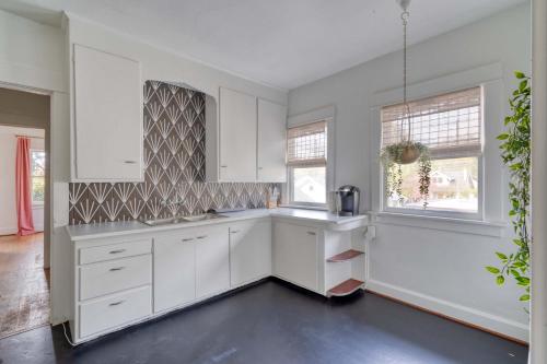 a white kitchen with white cabinets and windows at Stay Portland - Lively 2BR Old Hollywood Apt - 92 WalkScore in Marquam Hill