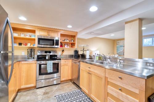 a kitchen with wooden cabinets and stainless steel appliances at Stay Portland - Private Underground Getaway - 92 WalkScore in Portland