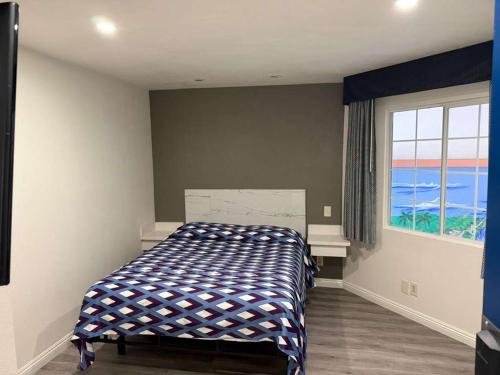 a bedroom with a bed in a room with a window at Vista Motel in Los Angeles