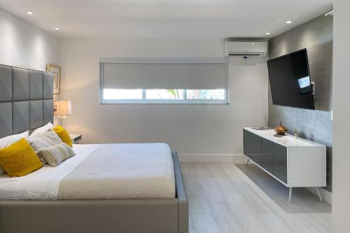 Un dormitorio con una cama grande y un televisor. en Relax in the Sun! Gem 1 Mi to Las Olas Beach, en Fort Lauderdale