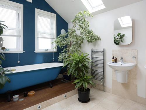 a bathroom with a large blue tub and a sink at Entire three bed house in wigginton, York in York