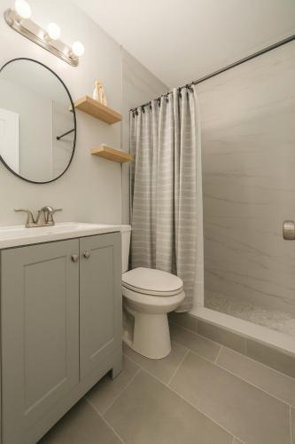 a bathroom with a toilet and a sink and a mirror at Layover Miami International Airport in Miami