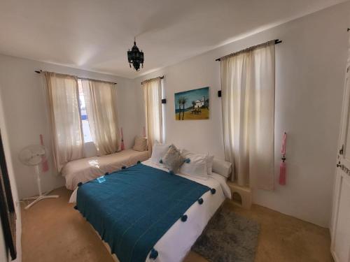ein Schlafzimmer mit einem Bett mit einer blauen Decke in der Unterkunft Villa Aloe Vera Privée in Essaouira