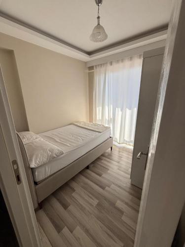a small bedroom with a bed and a window at Maraş Blue Life Suit in Kahramanmaraş