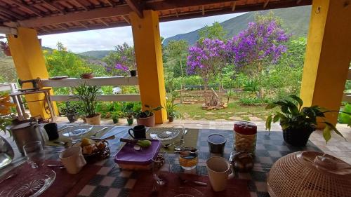 イビコアラにあるChalés Canto da Graúnaの紫色の花が咲く庭園が見えるテーブル