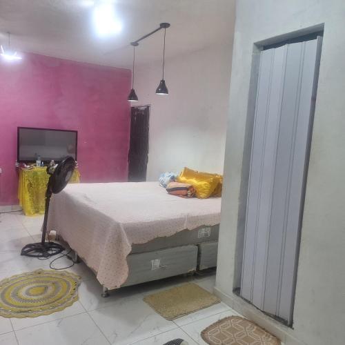 a bedroom with a bed and a pink wall at Casa da D Luiza in Belém
