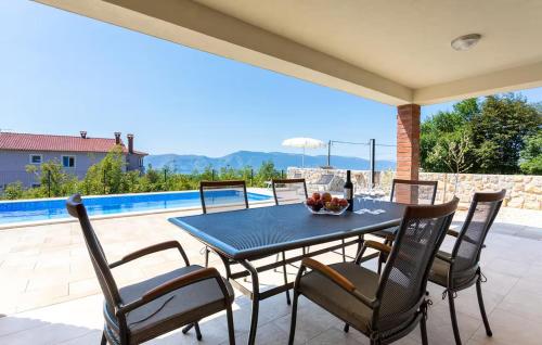 a table with chairs and a bowl of fruit on a patio at Lovely Home In Linardici With Private Swimming Pool, Can Be Inside Or Outside in Linardići