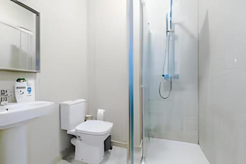 a bathroom with a shower and a toilet and a sink at 1 BR Flat By Eason Stays Short Lets & Serviced Accommodation Wigan With Free parking! in Wigan