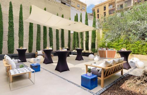a patio with couches and tables and a fence at H10 Art Gallery 4* Sup in Barcelona