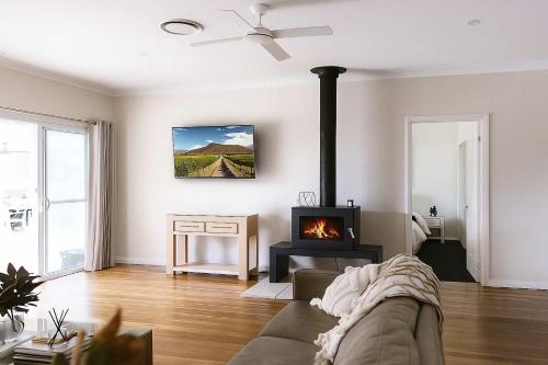 a living room with a couch and a fireplace at Semillon Retreat in Pokolbin