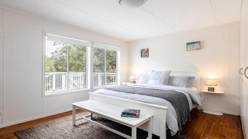 a white bedroom with a bed and a window at Walk To Beach, Pet Friendly Trampoline in Umina